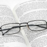 Reading glasses with light frame over the open book